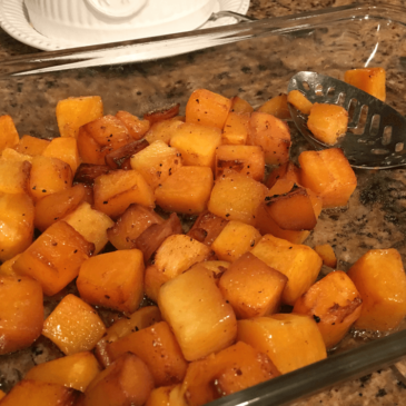 Roasted butternut squash in a glass dish with a spoon, prepared by a Certified Nutrition Consultant.