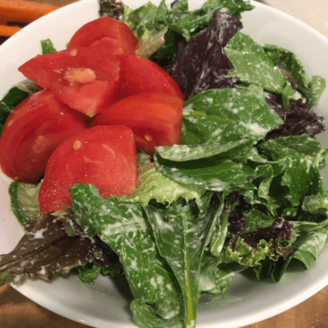 A bowl of real food salad packed with nutritious carrots and tomatoes, carefully curated by a certified nutritionist.