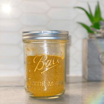 A mason jar filled with a vibrant yellow liquid, representing a delicious and nutritious concoction created by a Certified Nutrition Consultant. This wholesome drink is made from real food, expertly curated by