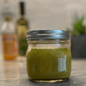 A jar of Real Food green sauce sitting on a counter.