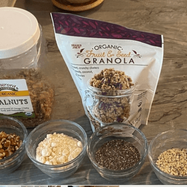 The ingredients for a real food granola bowl are shown on a counter, perfectly curated by a certified nutrition consultant.
