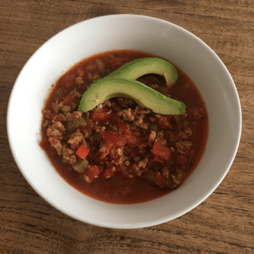 A delicious bowl of chili topped with nourishing avocado.
