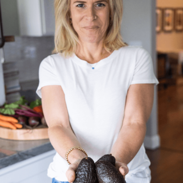 Certified nutrition consultant Molly Obert holds a bunch of real food avocados in her kitchen.