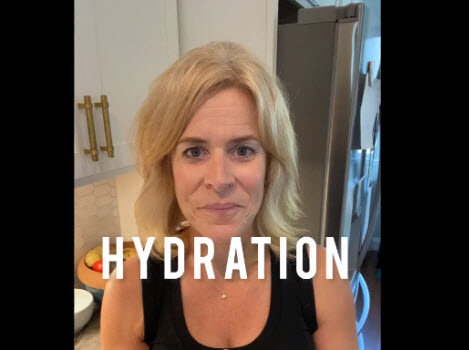 A certified nutrition consultant is standing in front of a kitchen, emphasizing the importance of real food for proper hydration.