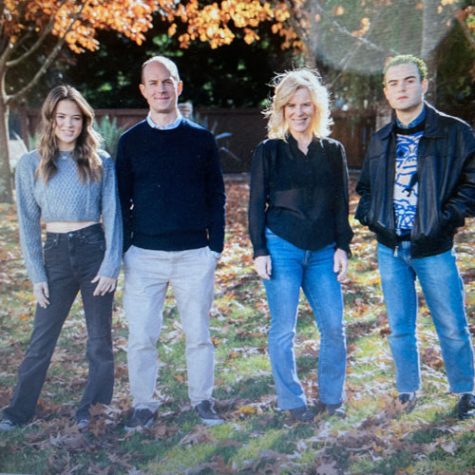 Molly Obert with her husband and their two adult children posing for a picture in the fall, capturing their joy and camaraderie.